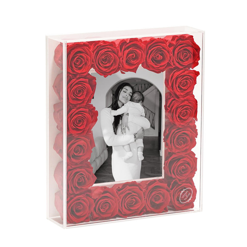 Photo frame with red roses surrounding a black-and-white photo of a woman holding a baby. A rose in the bottom right corner has a label reading 'VENUS FLEUR'.